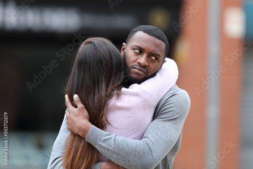 Fotobehang Disappointed man with black skin hugging a woman