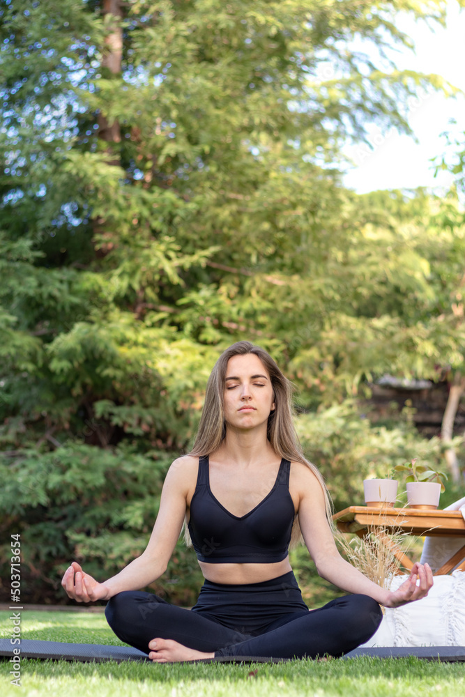 Vertical view of young woman enjoying her meditation moment time in the garden with copy space Vertical view of young woman enjoying her meditation moment time in the garden with copy space
