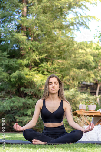 Vertical view of young woman enjoying her meditation moment time in the garden with copy space © NOWRA photography