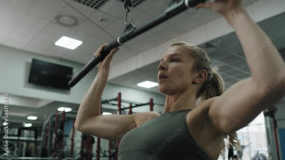 Young woman exercising with weights on a gym. Shot with RED helium camera in 8K. Young woman exercising with weights on a gym. Shot with RED helium camera in 8K.