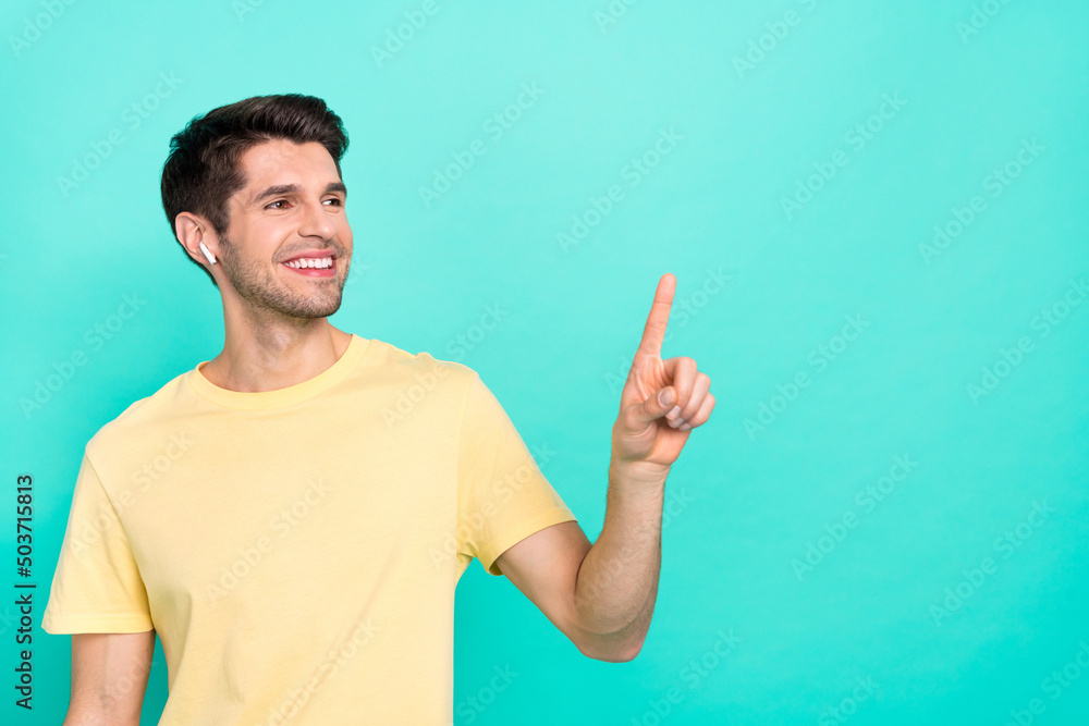 Photo of optimistic brunet millennial guy index promo wear t-shirt headphones isolated on teal color background Photo of optimistic brunet millennial guy index promo wear t-shirt headphones isolated on teal color background