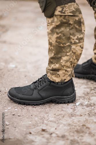 Military man in black tactical sneakers