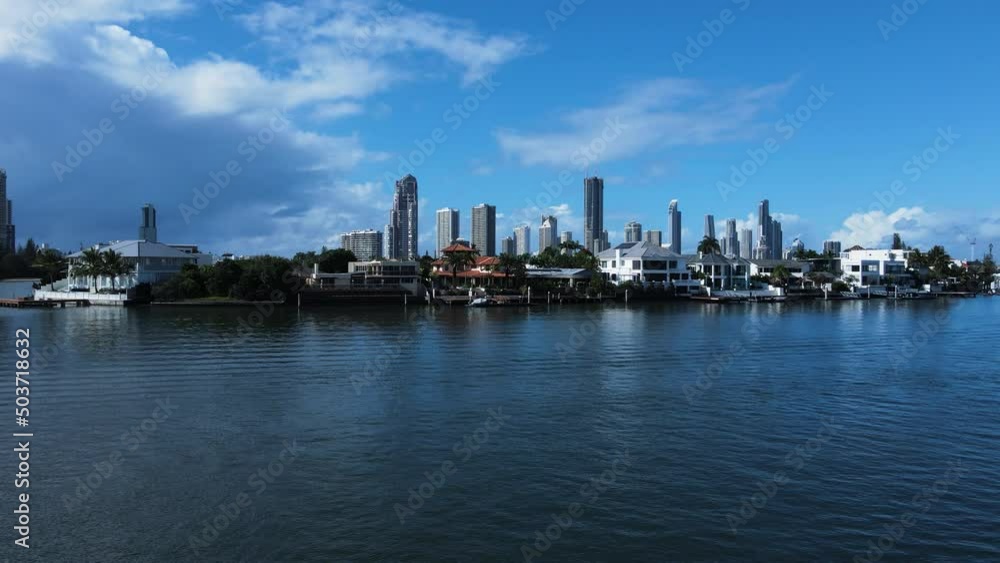 Gold Coast luxury waterfront properties with a towering intercity skyline backdrop. Static drone view Gold Coast luxury waterfront properties with a towering intercity skyline backdrop. Static drone view