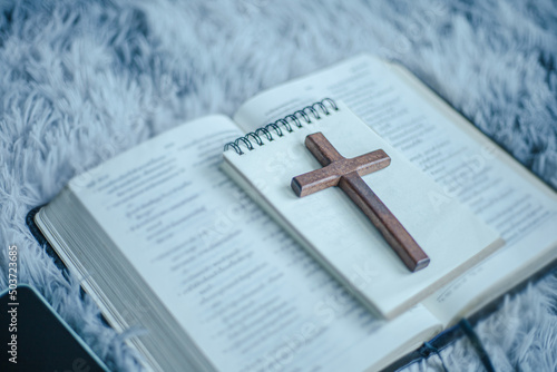 Holy Bible and wooden cross, symbol of christian concept.