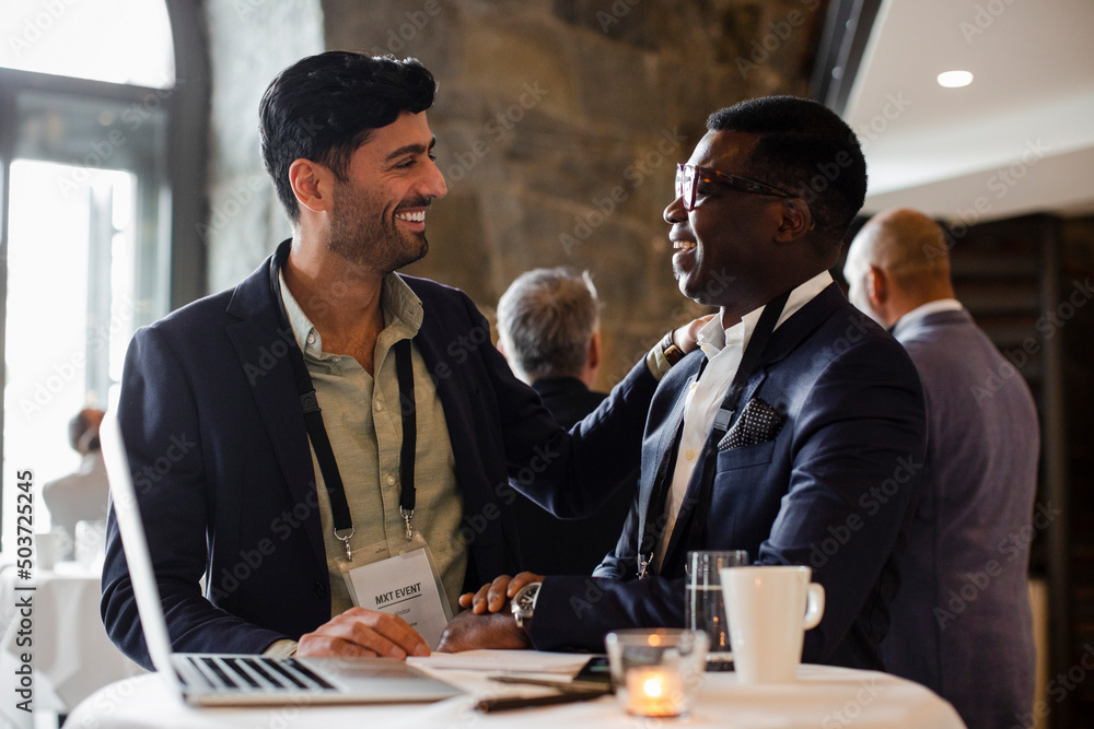 Happy businessmen looking at each other during seminar Happy businessmen looking at each other during seminar