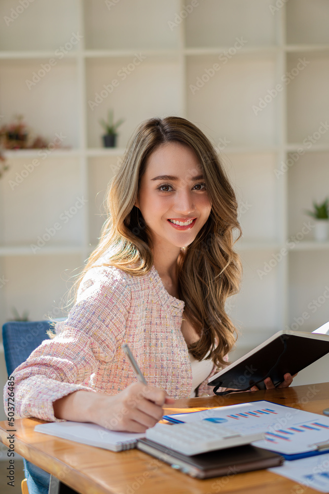 businesswoman or accountant Asian girl working on laptop Financial investment trading concept with a calculator. Calculate. Analyze business and market growth on an accounting data graph. Economy businesswoman or accountant Asian girl working on laptop Financial investment trading concept with a calculator. Calculate. Analyze business and market growth on an accounting data graph. Economy