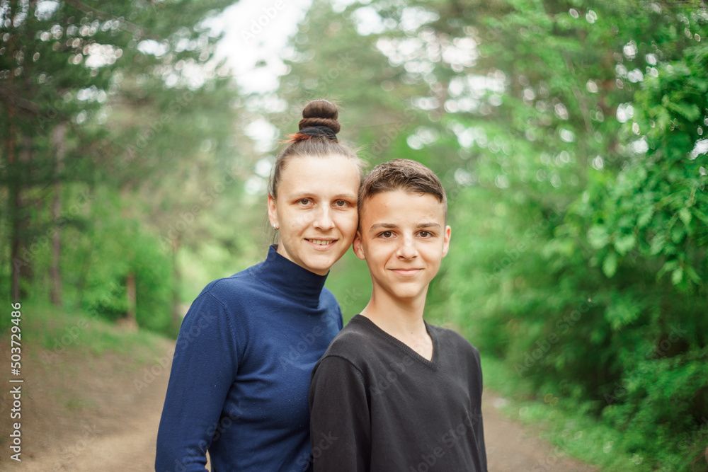 smiling mother and son, portrait in a nature park