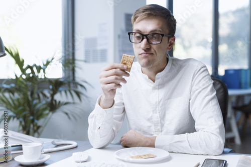 Foto Sad office worker eating a very small meal
