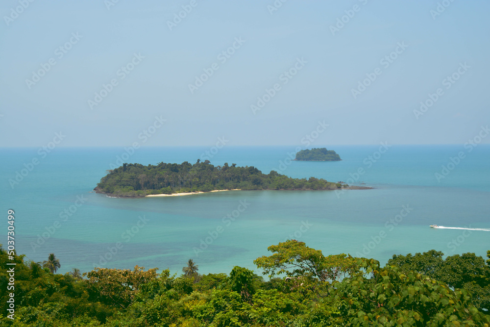 Obraz premium Beautiful landscapes island on the blue sea and speed boat drive through the island. Snap shot on the other side of the island.