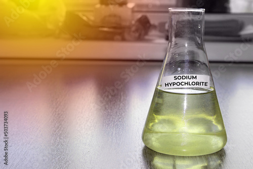 Sodium hypochlorite in glass flask. Formula NaClO. The concept of a chemical reagent for a product card on a website. High quality photo