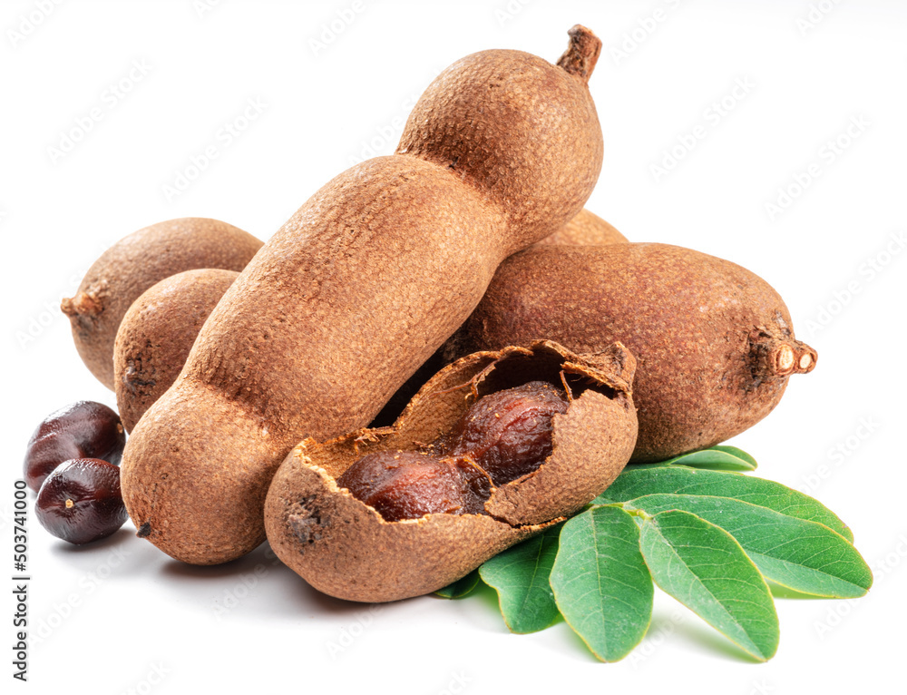 Ripe tamarind fruit, leaves and some tamarind seeds isolated on white background. Stock Photo
