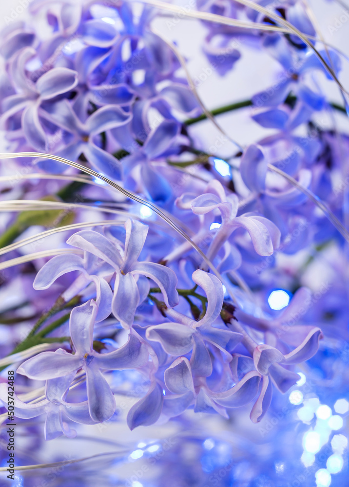 a background of lilac flowers with a blue LED garland