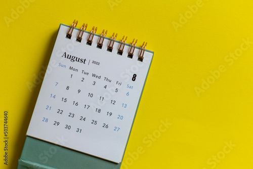 Desktop mini calendar for August 2022 on the table.