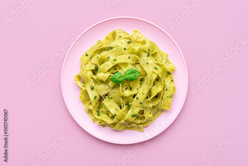 Pasta with pesto sauce minimalist on a pink background