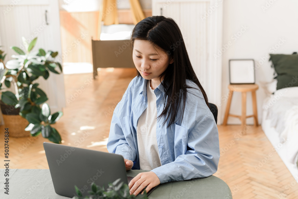 Business asian woman working on laptop at home. Small business owner or freelancer is trained in a home environment Business asian woman working on laptop at home. Small business owner or freelancer is trained in a home environment