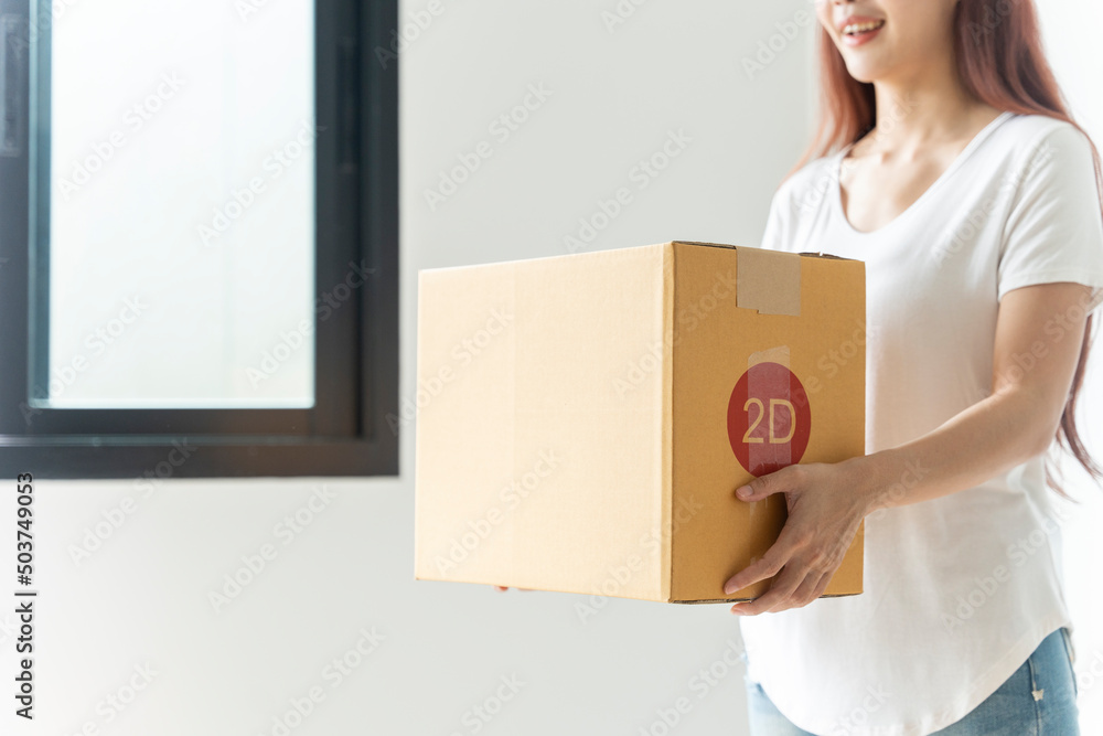 Asian woman packing boxes to move house which they live happily holding a big box. Asian woman packing boxes to move house which they live happily holding a big box.