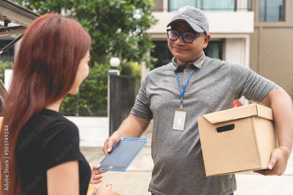 delivery man holding a large box to send to customers in front of the house delivery man holding a large box to send to customers in front of the house