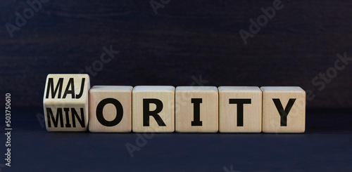 Minority or majority symbol. Turned wooden cubes and changed the concept word Minority to Majority. Beautiful black table black background. Minority or majority and business concept. Copy space.