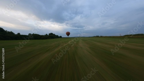 air balloon cruising along the green field photo