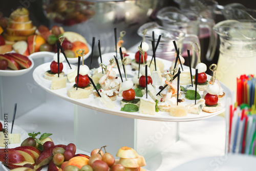 Catering table buffet dinner, beautifully decorated banquet with variety of different food snacks and appetizers on corporate birthday party event or wedding reception, canape, delicatessen setting