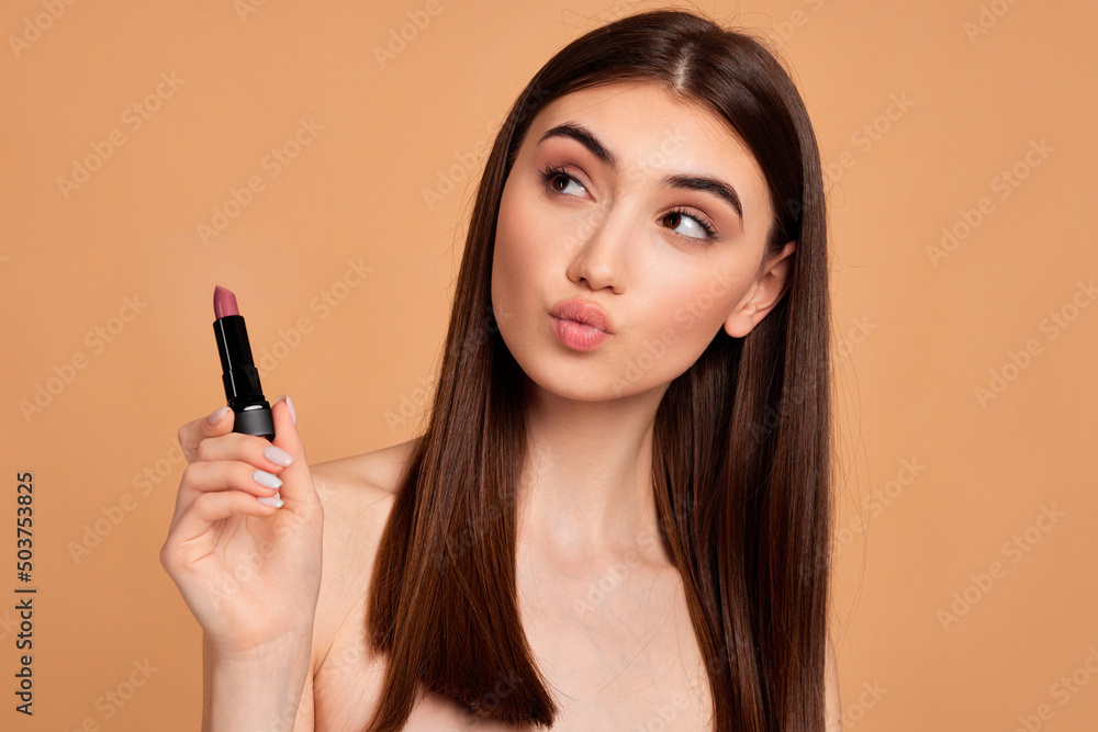 young happy positive woman holding pink lipstick young happy positive woman holding pink lipstick