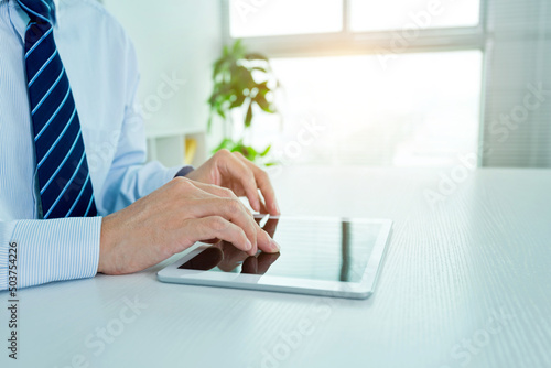 Close up of businessman working on his digital tablet