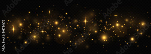 Golden shimmering background with light effect. The dust sparks and golden stars shine with special light on a transparent background. Christmas concept.