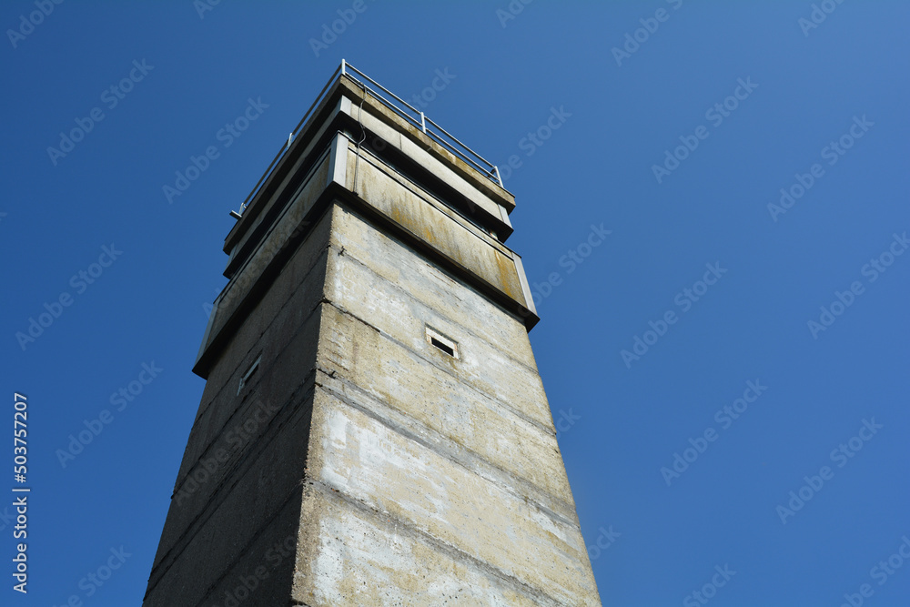 An old watchtower of a former GDR border fortification with a blue sky