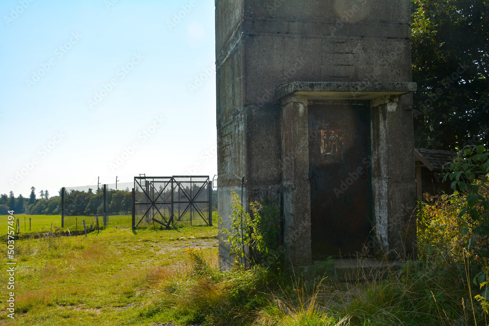 Lower part of an old watchtower of a former GDR border fortification with a rusted door