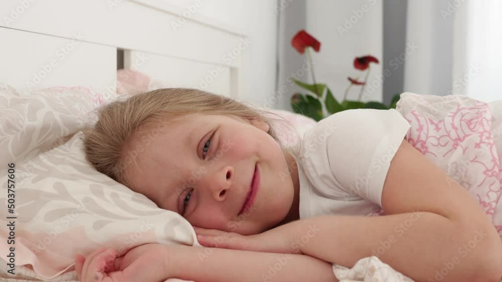 person sleeping Little beautiful girl with blue eyes lies in a baby bed. The baby turns over in bed. The child went to bed. Children's sleep person sleeping Little beautiful girl with blue eyes lies in a baby bed. The baby turns over in bed. The child went to bed. Children's sleep