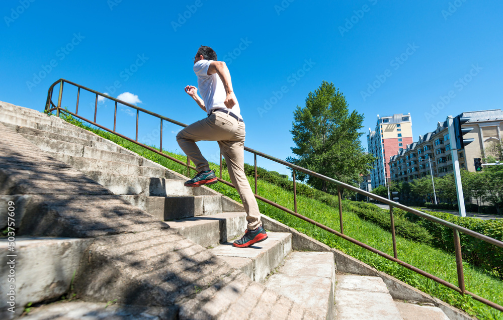 Rear view of young man running up on steps