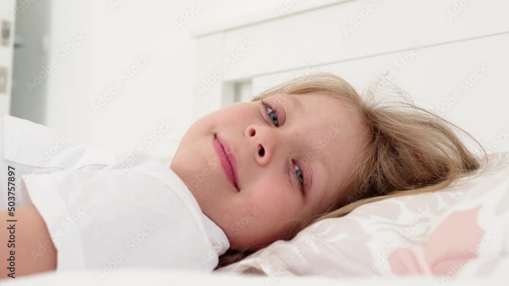 person sleeping. A small beautiful girl with blue eyes turned her face. The child is in bed. Wide open baby blue eyes. person sleeping. A small beautiful girl with blue eyes turned her face. The child is in bed. Wide open baby blue eyes.