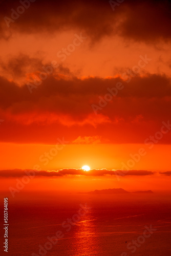 Red sun in the clouds. Great dramatic view. Amazing sky panorama. Colorful sunset in the evening sky. Clouds illuminated by the setting sun. Meditative calmness and greatness