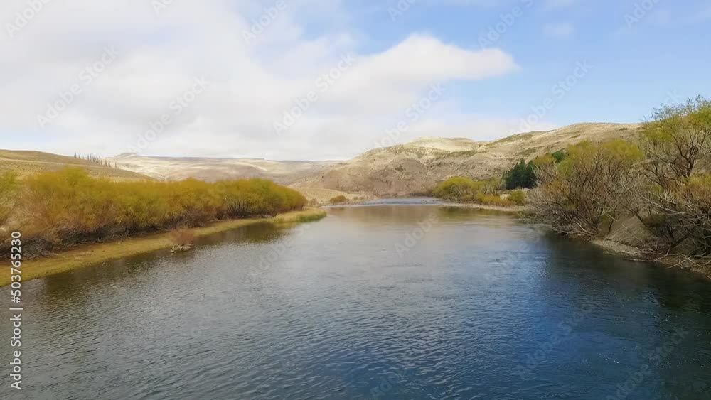 Magical rural landscape in autumn. Aerial shot of the river flowing across the yellow valley. View of the hills, blue sky and clouds reflection in the water surface. Magical rural landscape in autumn. Aerial shot of the river flowing across the yellow valley. View of the hills, blue sky and clouds reflection in the water surface.