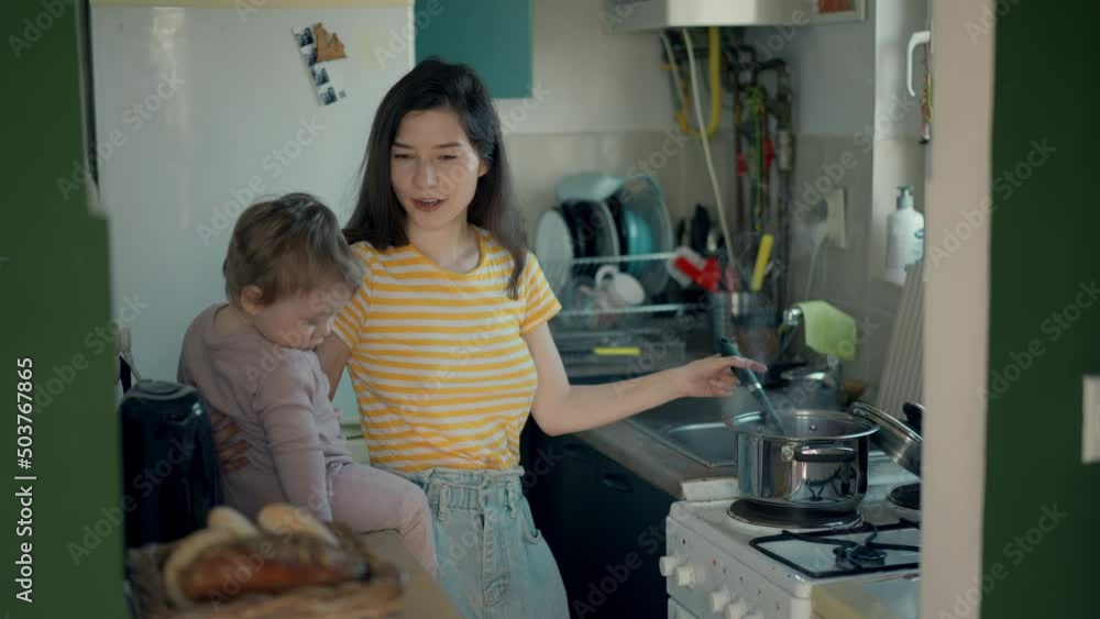 Cinematic authentic shot of happy mother and her little toddler baby boy son are having fun to make dough with flour together for baking cookies or bread in kitchen at home. Cinematic authentic shot of happy mother and her little toddler baby boy son are having fun to make dough with flour together for baking cookies or bread in kitchen at home.