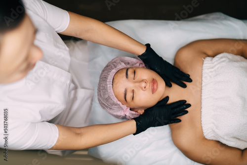 Beautician do massage of girl body in beauty salon