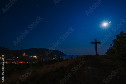 Evening landscape. The Cross of God on a hill overlooking the outskirts of the city and the sea. A small town in the Crimea. Marine.