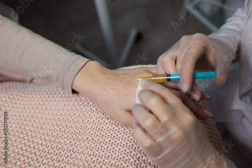 Doctor doing stem cell therapy on a patient's elbow after the injury. Treating knee pain with platelet-rich plasma injection. Treatment of arthritis and osteoarthritis.Medical and cosmetology concept. photo