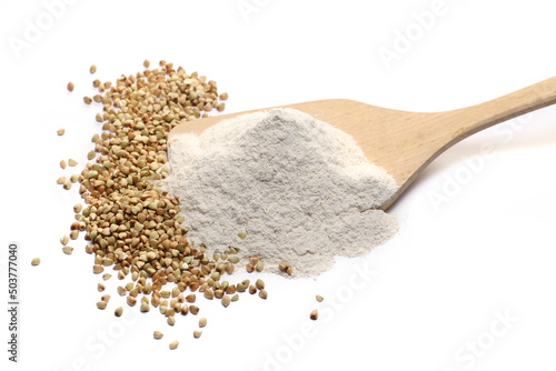 Buckwheat flour and grain in wooden spoon isolated on white  