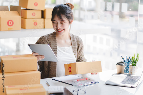 Portrait of a Small Business Startup, SME Owner, Female Entrepreneur work on parcel boxes Receipts and check orders online to prepare boxes. Selling to customers. Online SME business idea.