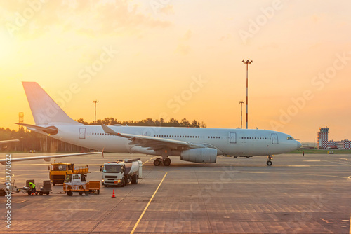 Side view of the plane passing after the poisoning from the terminal building to take off, at sunset.