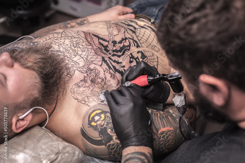 Tattooist works in the salon photo