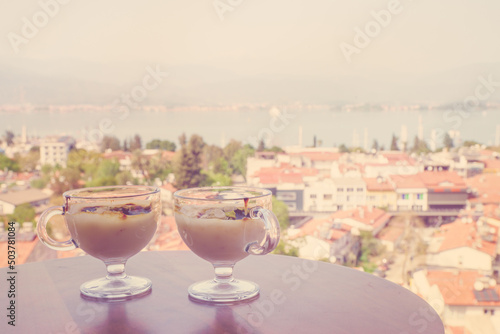 Sweetness for breakfast on the background of the seaside city. Delicious treat from Turkey. Traditional Turkish pudding. A postcard from Turkey photo