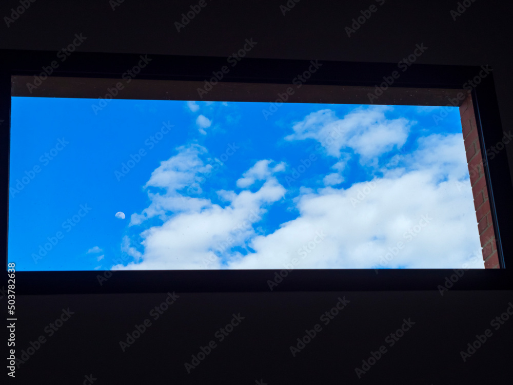 Fototapeta premium Ventana con el cielo con nubes y la luna 
