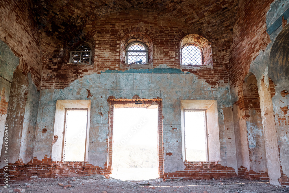 The old temple is viewed from the inside, the abandoned church, the broken windows, the bright sunlight falls into the windows, the ancient walls of the building, the red brick,