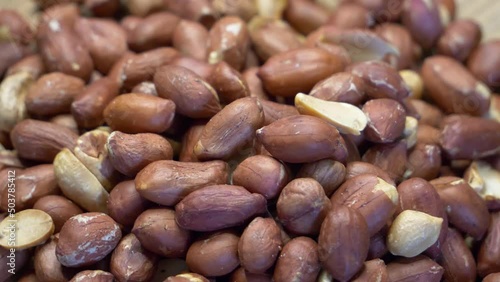 Roasted peanuts in the peel. Peanuts close-up. Highly detailed macro video. Peanuts full frame image. photo