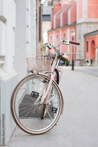 Vintage pink bycicle parked on the city street