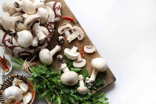 Funghi champignon freschi e ingredienti per cucinare su sfondo bianco. Cucinare funghi biologici. Direttamente sopra. Copia spazio.