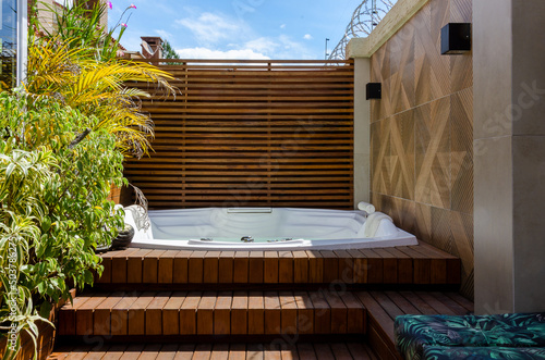garden wooden deck with a jacuzzi at sunlight