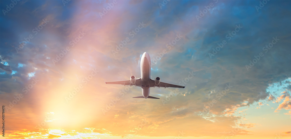 White passenger airplane flying in the sky amazing clouds in the background - Travel by air transport